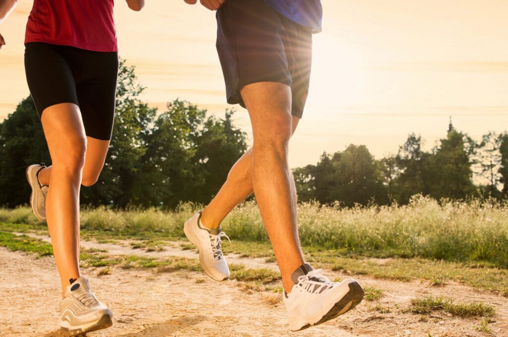 Two runners on an Albuquerque trail at sunrise, representing active recovery through physical therapy
